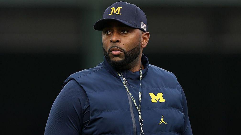 Fired University of Michigan football coach charged with stalking